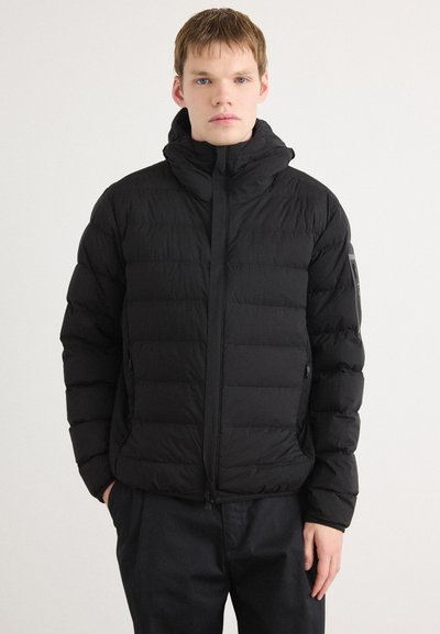 Doudoune noire avec capuche, présentant un motif matelassé horizontal, des poches latérales et une fermeture éclair à l'avant. Texture douce et isolante.