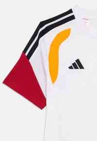 T-shirt de sport Adidas avec un corps blanc, des manches texturées rouges, noires et jaunes, avec trois bandes noires et le logo à l'avant.