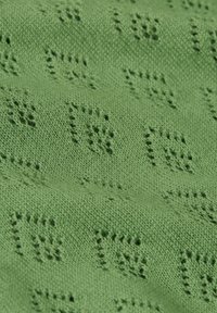 Tessuto lavorato a maglia verde chiaro con un motivo testurizzato di piccoli quadrati rialzati. Texture morbida con una finitura liscia e uniforme.