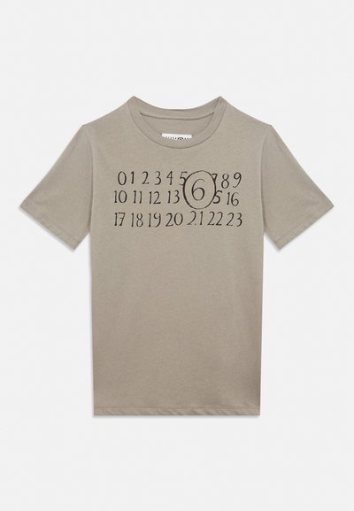 Τζάμπα καφέ κοντομάνικο μπλουζάκι με μαύρους τυπωμένους αριθμούς από το 0 έως το 23 σε τρεις σειρές, ο αριθμός 6 είναι κυκλωμένος στο κέντρο του σχεδίου.