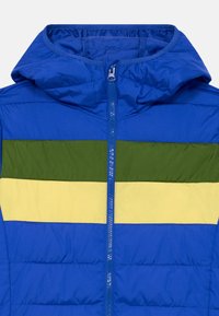 Blå puffjacka med horisontella gröna och gula ränder, dragkedja fram och fast huva.