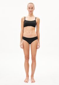 Zwarte bralette en bijpassende slip met een gladde textuur. Eenvoudig ontwerp met dunne bandjes en een subtiel logo op de tailleband.