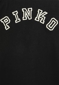 Tessuto di cotone nero con la parola "PINKO" in maiuscolo, ricamo bianco testurizzato nella parte superiore.