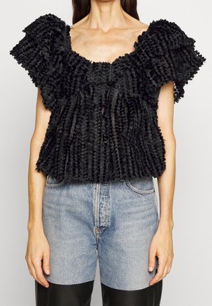 Czarny teksturowany top z marszczonymi ramionami, z kwadratowym dekoltem i luźnym krojem, zestawiony z jasnoniebieskimi dżinsami.