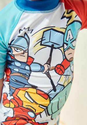 Lyhythihainen rash guard, jossa on värikäs sarjakuvatyylinen printti supersankareista Thorista, Kapteeni Amerikasta ja Iron Manista. Sininen, punainen ja valkoinen värimaailma.
