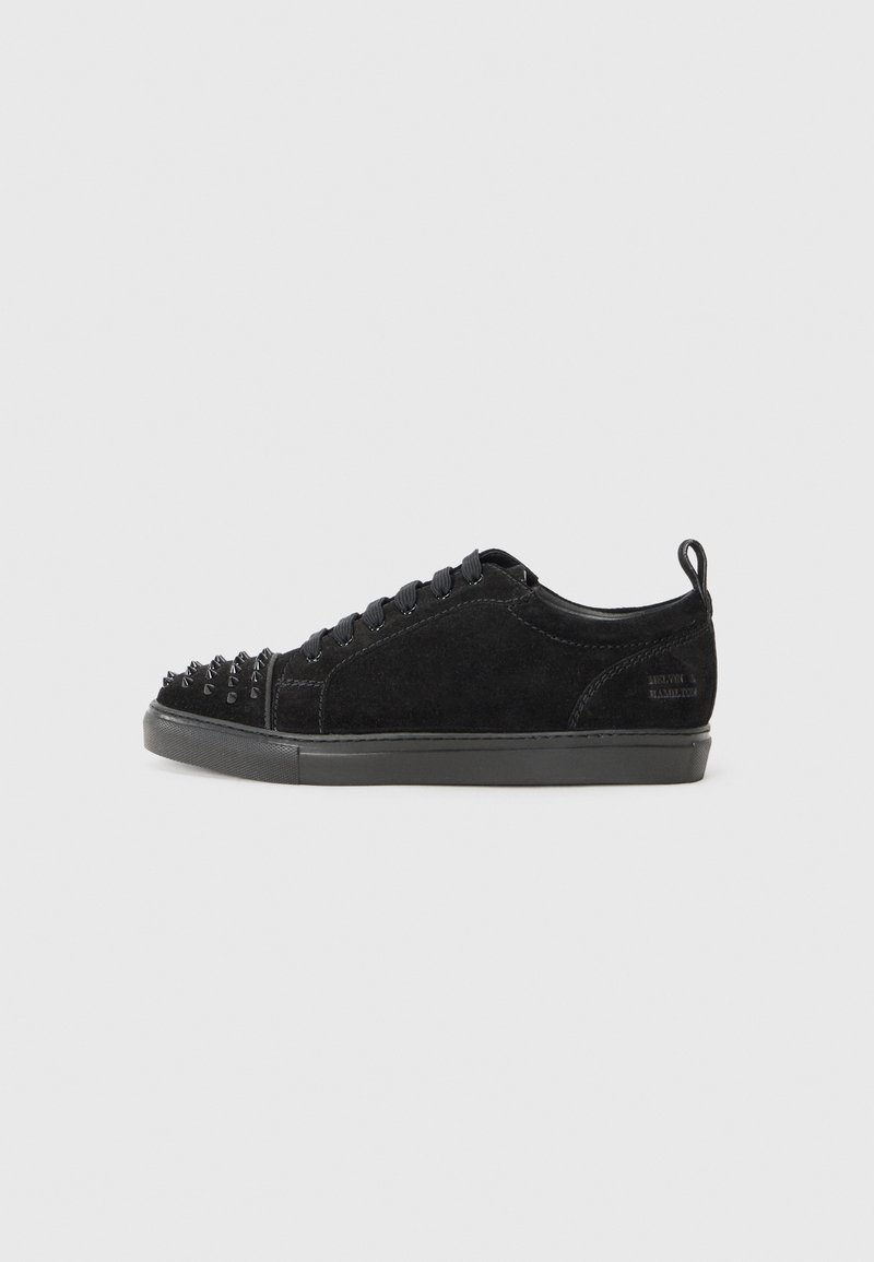 Black suede sneakers with a rounded toe, featuring a spiked design on the front, black laces, and a textured black rubber sole.