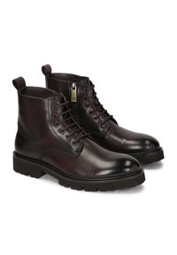 Botas de tobillo de cuero marrón con acabado suave, parte delantera con cordones, cremallera lateral y suela gruesa. Presenta una pestaña para tirar y costuras decorativas.