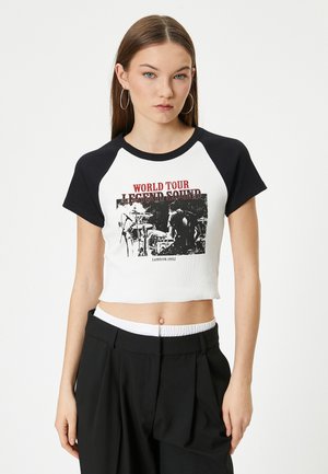 Kortærmet t-shirt i hvid med sorte raglanærmer. Har et grafisk print med teksten "WORLD TOUR LEGEND SOUND" og "LONDON 1992".