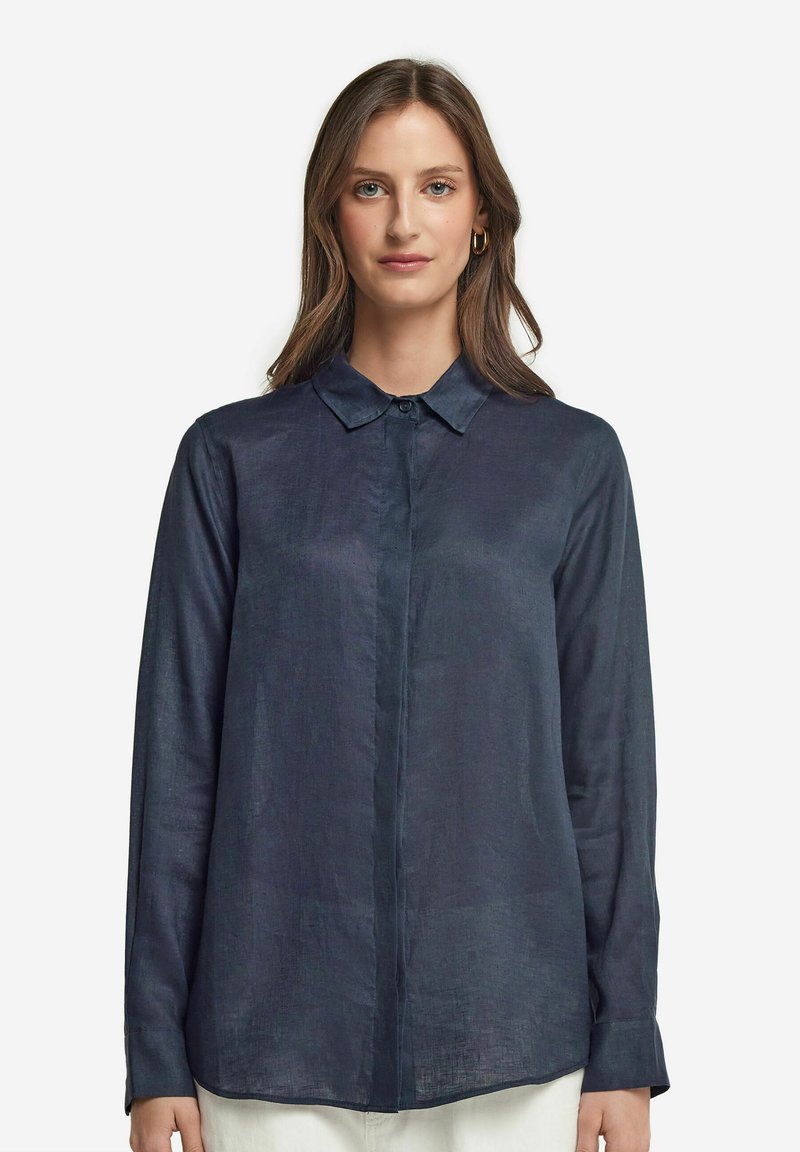 Mörkblå långärmad skjorta i lätt material med spetsig krage, framknäppning och en lätt strukturerad yta.