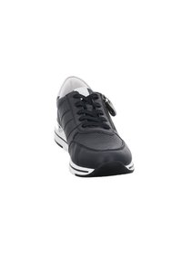 Schwarze Ledersneaker mit perforiertem Design, flachen schwarzen Schnürsenkeln und weißen Sohlenakzenten. Verfügt über einen Reißverschluss an der Seite.