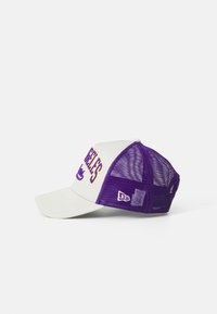 Vit och lila basebollkeps med nätbak, böjd skärm, broderad "LOS ANGELES" och logotyp på sidan. Justerbar strapstängning.