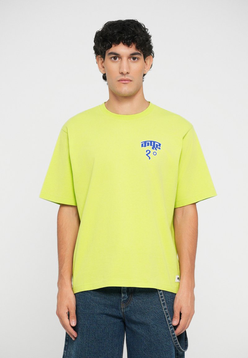 Neon yellow short-sleeve t-shirt made of cotton, featuring a blue graphic design on the left chest area. Straight-cut hem and relaxed fit.