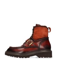 Botas de tobillo de cuero y ante marrones con una suela robusta, que cuentan con una correa con hebilla, puntera redonda y un acabado texturizado.