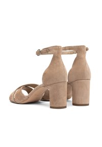 Sandali con tacco in camoscio beige, caratterizzati da una larga fascia alla caviglia e un design con ritagli. Il tacco quadrato offre stabilità e comfort.