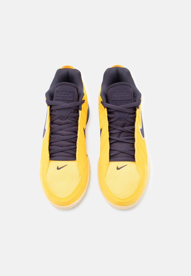 Yellow athletic shoes with a textured mesh upper, dark navy accents, and a white Nike swoosh logo. Includes laces and padded collar.