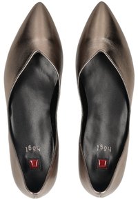 Pointed-toe flats in metallic bronze leather with black insoles, featuring a red decorative detail at the heel and a smooth surface texture.