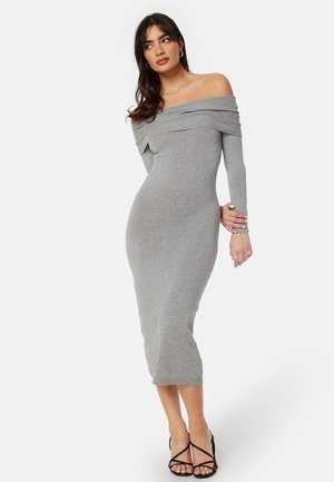 Robe grise décolletée, avec une coupe ajustée, des manches longues et un col côtelé, arrivant mi-mollet. Texture lisse, élégance simple.