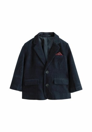 Blazer en velours côtelé bleu marine foncé à deux boutons, deux poches à rabat, avec un mouchoir de poche rouge dans la poche poitrine.