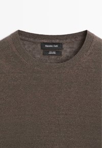 Brauner Leinenpullover mit Rundhalsausschnitt, geripptem Kragen und schwarzem Etikett mit der Marke Massimo Dutti sowie Stoffdetails.