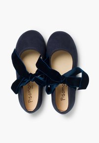 Bailarinas de ante azul marino con punta redondeada y cintas de terciopelo suaves atadas alrededor del tobillo. Interior beige que presenta la etiqueta de la marca.