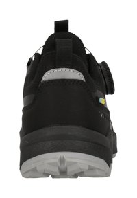 Svart idrottssko med ett texturerat tygöverdrag, en dragflik, runda knappstängningssystem och en slitstark grå gummisula.