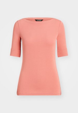 Brzoskwiniowy t-shirt z krótkim rękawem, okrągłym dekoltem, gładką fakturą i podwiniętymi mankietami. Posiada dopasowany krój i schludny dół.