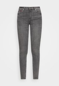 Jeans skinny grises de denim, con un diseño clásico de cinco bolsillos, cierre de cremallera y botón de metal. Desgaste sutil y textura.