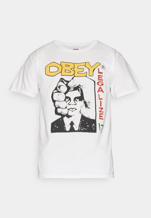 Biała koszulka z grafiką twarzy mężczyzny częściowo zasłoniętej dużą dłonią, żółty tekst "OBEY" i czerwony tekst "LEGALIZE" z przodu.