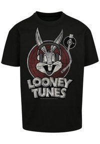 Juodas marškinėliai su grafiniu dizainu, vaizduojančiu Bugs Bunny su ausinėmis, apskritu raudonu fonu ir žodžiais "LOONEY TUNES" apačioje.