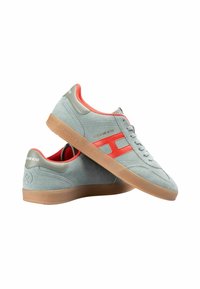 Szare zamszowe sneakersy z czerwonym akcentem, z gumową podeszwą i fakturowanymi detalami. Logo widoczne jest na pięcie i boku.