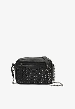 Black crossbody bag made of faux leather, featuring silver studs, a wavy design on the front, and a detachable chain strap.