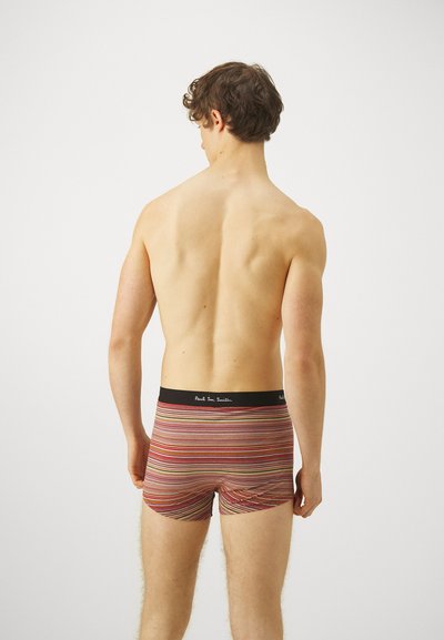 Boxers en coton rayés avec une ceinture noire portant un texte blanc. Les rayures comportent différentes couleurs telles que le rouge, l'orange et le jaune.