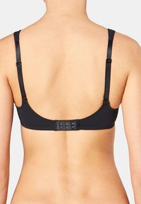 Černá podprsenka s nastavitelnými ramínky, uzávěrem na háček a oko, hladkým materiálem a minimalistickým designem, zobrazená z pohledu zezadu.