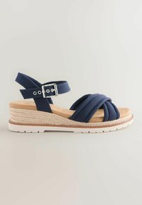 Sandale compensée bleu marine avec semelle en jute tressée, semelle extérieure en caoutchouc blanc, bride de cheville ajustable et empeigne en tissu rembourré croisée.