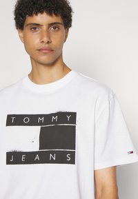 Tommy Jeans SPRAY FLAG TEE UNISEX - Triko s potiskem - white