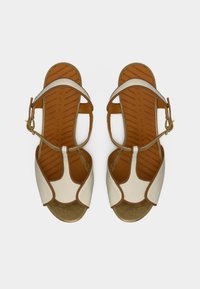 Λευκά δερμάτινα σανδάλια με χρ υσές λεπτομέρειες, με σχέδιο λουριών και ανοιχτά δάχτυλα. Καφέ εσωτερική σόλα με υφή και γραμμικά σχέδια. Ρυθμιζόμενο κούμπωμα.