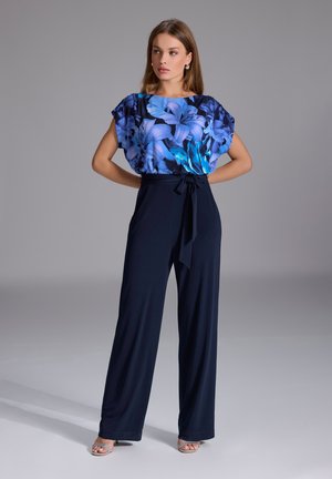 Haut à manches courtes à motif floral bleu, associé à un pantalon large noir marine, doté d'un lien à la taille et d'une texture lisse.