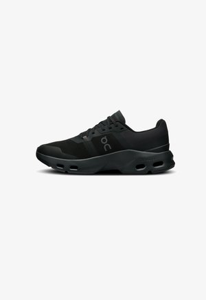 Black athletic shoe with a textured upper, mesh panels, and a cushioned sole featuring air holes for breathability and impact absorption.