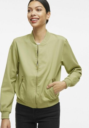 Veste bomber vert clair avec fermeture éclair à l'avant, poches latérales, poignets côtelés et taille ajustée. Tissu lisse avec une finition mate.