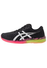 Zapatilla deportiva negra con parte superior texturada y un logo plateado. Cuenta con una suela vibrante en rosa y verde con un diseño moteado.