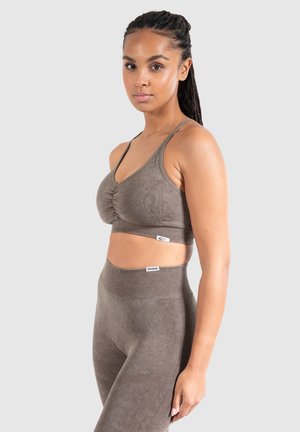 Bruine sport-BH met een textuur, dunne bandjes en geraffineerde details, gecombineerd met high-waisted leggings met een gladde afwerking en naden.