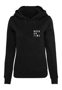 Black hoodie featuring a front pocket, ribbed cuffs, and hem. The text "NEVER ON TIME" is displayed in white, block letters on the chest.