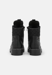 Botines negros con parte superior acolchada, material de cuero, cierre de doble cremallera y suela de goma texturizada con acentos de costura blanca.