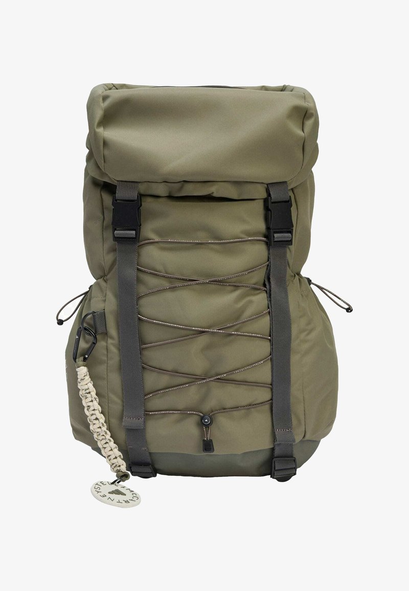 Mochila de nylon verde oliva con diseño de apertura enrollable, correas ajustables, cordón elástico frontal y un llavero decorativo. Textura suave.