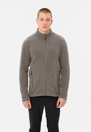 Graue Fleecejacke mit hohem Kragen, Reißverschluss vorne und zwei Seitentaschen. Sie verfügt über ein kleines Logo auf der Brust und einen weichen, strukturierten Stoff.