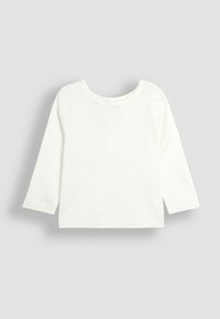 Ilgo rankovėmis marškinėliai iš off-white (kreminės baltos) medvilnės su apvaliu iškirpimu ir subtiliu tekstūriniu raštu, kuriame yra sagos uždarymo detale nugaroje.