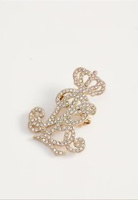 Gold brooch in ornate scroll design adorned with clear rhinestones, featuring a crown shape at the top and a clip fastening on the back.