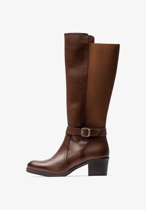 Bota marrón de cuero hasta la rodilla con un panel superior texturizado, una correa con hebilla en el tobillo y un tacón grueso para mayor estabilidad.