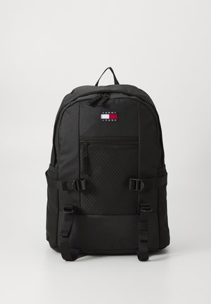 Schwarzer Rucksack mit vorderer Reißverschlusstasche, verstellbaren Riemen und Tommy Jeans Logo-Patch in der oberen Mitte.