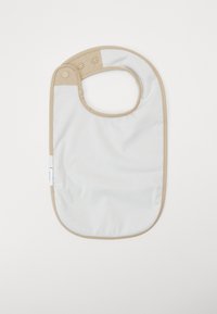 Bavoir en mélange coton blanc avec des accents marron, ouverture ronde au niveau du cou, pressions à bouton-pression et finition imperméable pour un nettoyage facile.